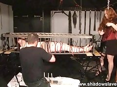 Kinky couple sexually burn their bound and caged brunette slave