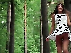 Beautiful brunette in a short dress in the woods
